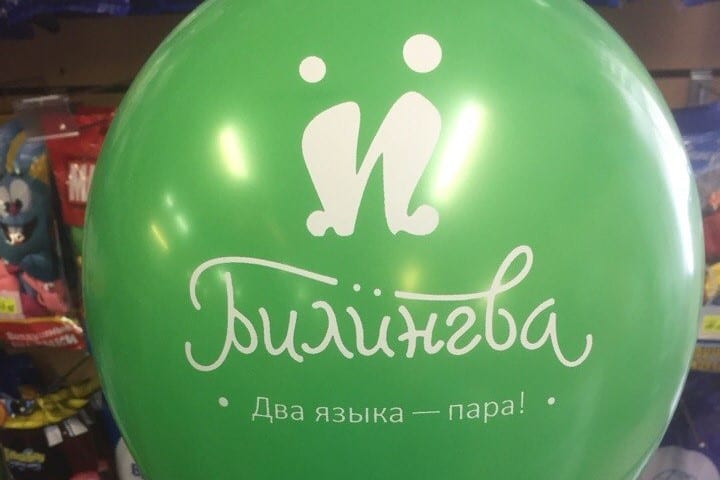 Фото зеленый воздушный шар с надписью билингва, два языка - пара