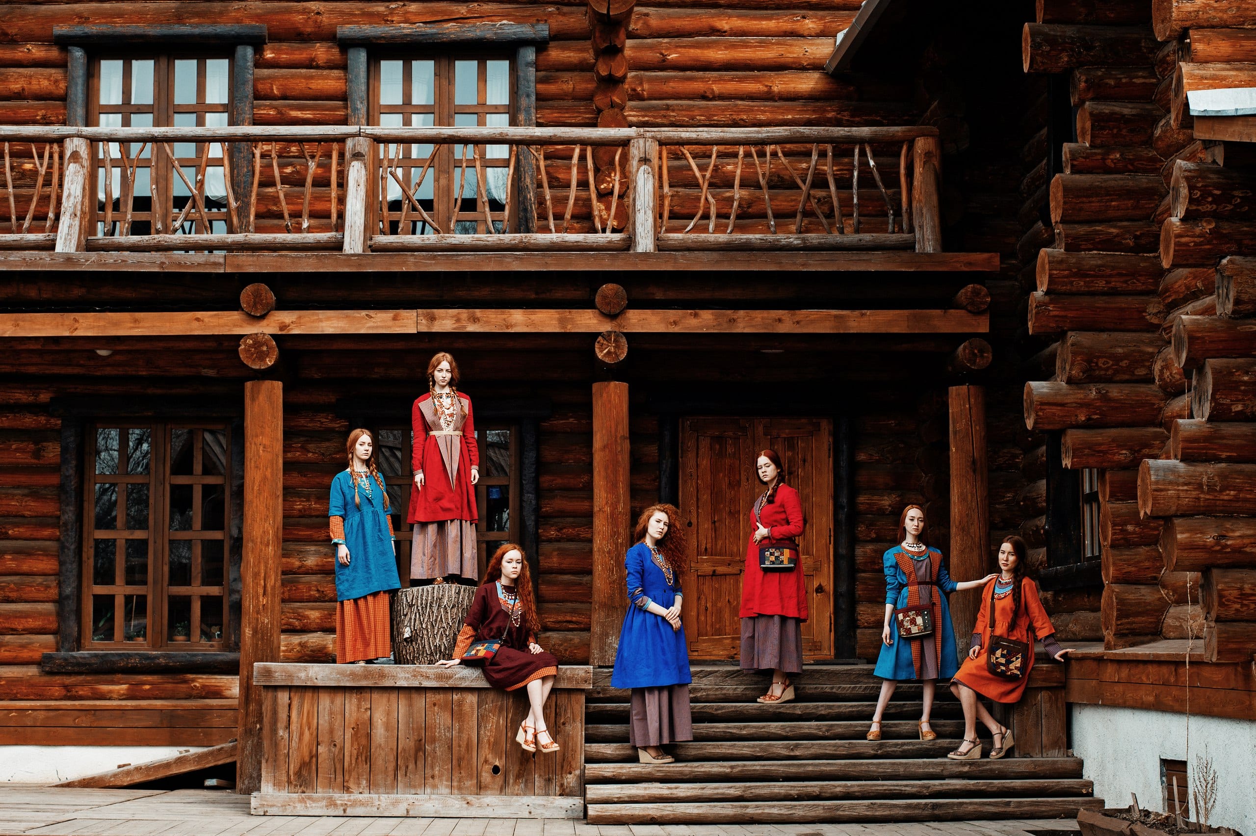 Девушки в этнических костюмах на фоне деревянного особняка