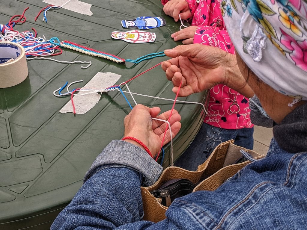 Фото мастер-класса, бабучка плетёт браслет цвета российского триколора