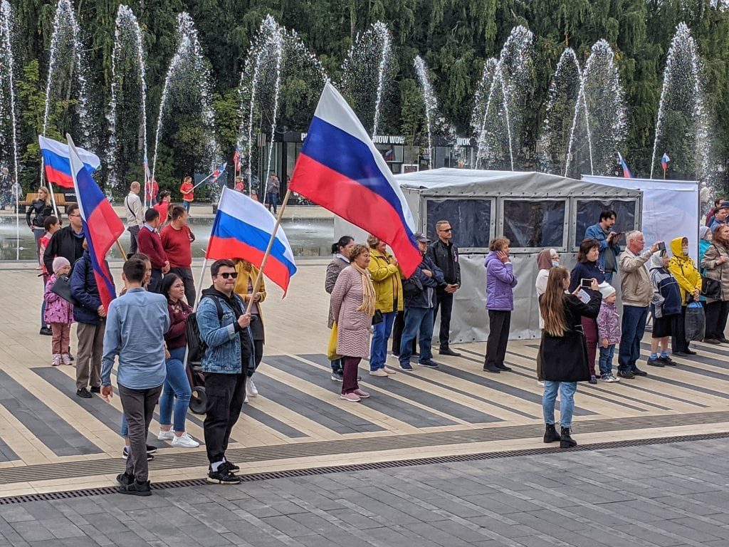 Фото люди на фоне фонтанов ходят с флагами россии