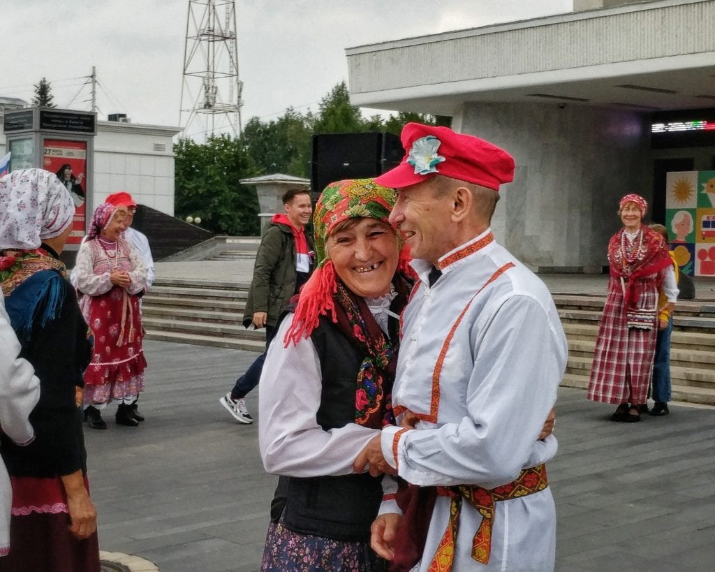 Фото мужчина и женщина в национальных русских костюмах улыбаются и смеются