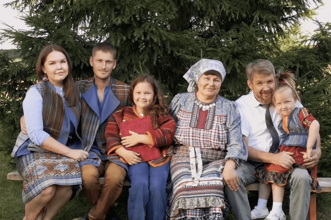 Фото семьи на скамейке в комплектах удмуртской современной одежды