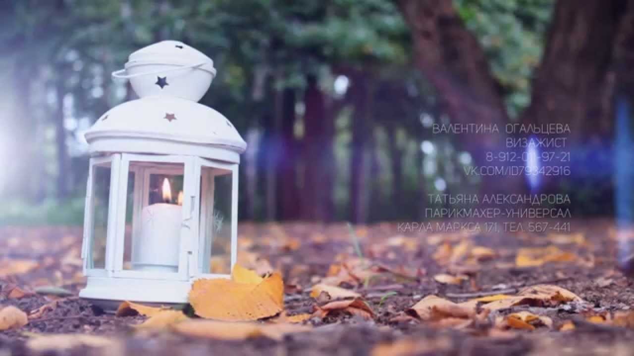 Фото свеча в закрытом фонаре стоит на земле в осеннем парке с пожелтевшей листвой