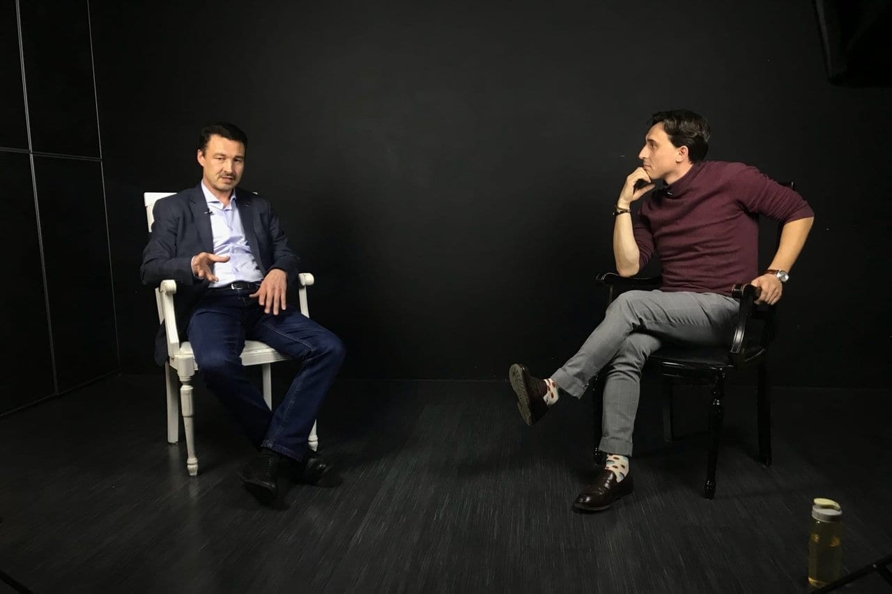 Фото двое мужчин общаются в тёмной студии на съёмках видеолекций "тубат"