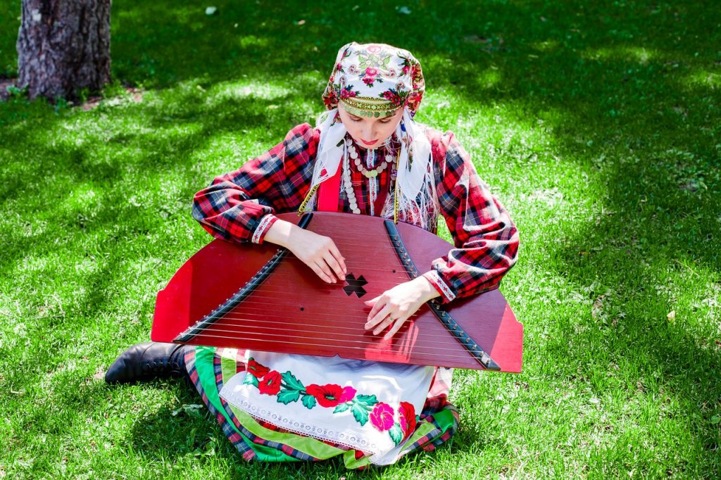 Женщина играет на удмуртском национальном инструменте – крезе